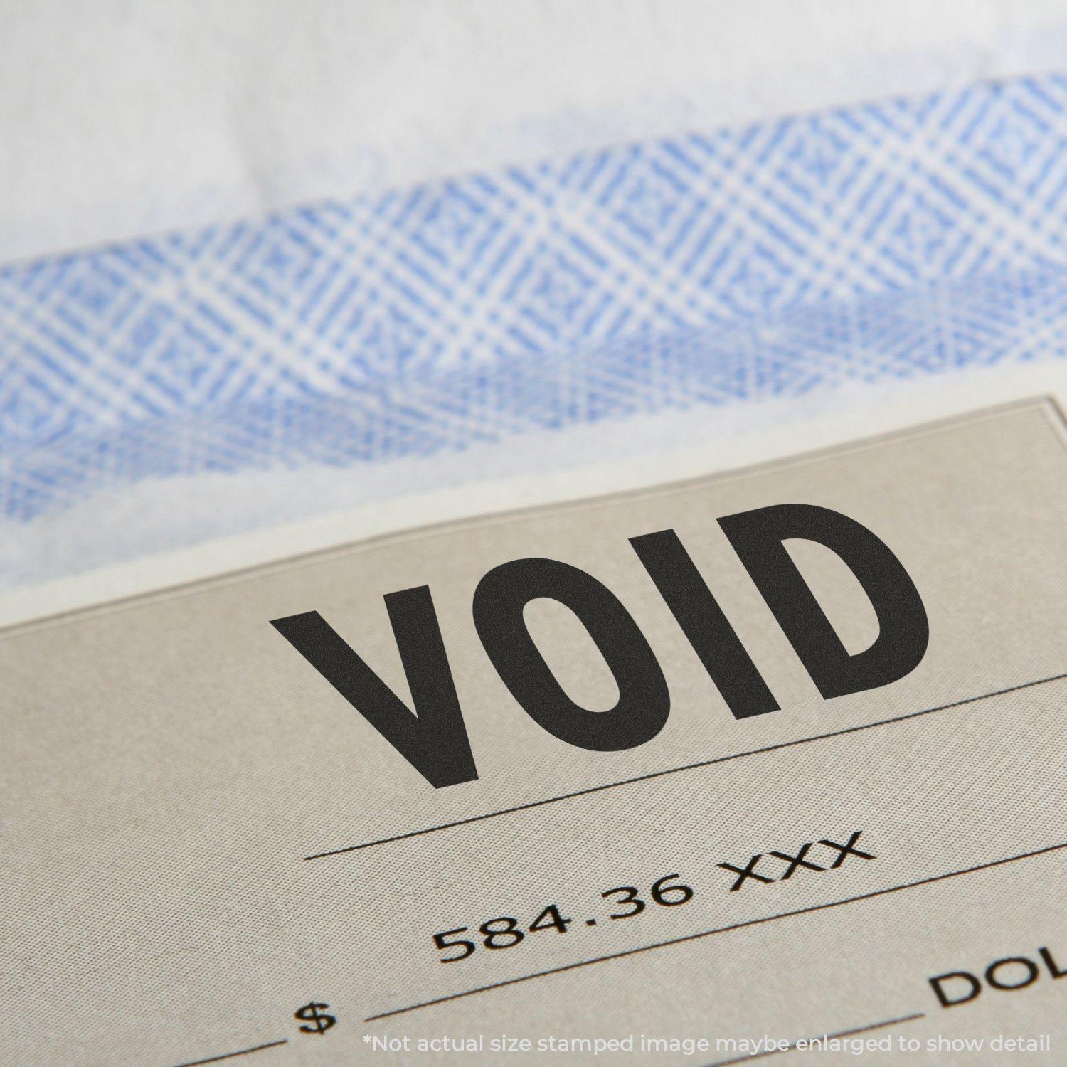 Close-up of a document stamped with VOID using the Large Pre-Inked Void Stamp, with a check background visible.