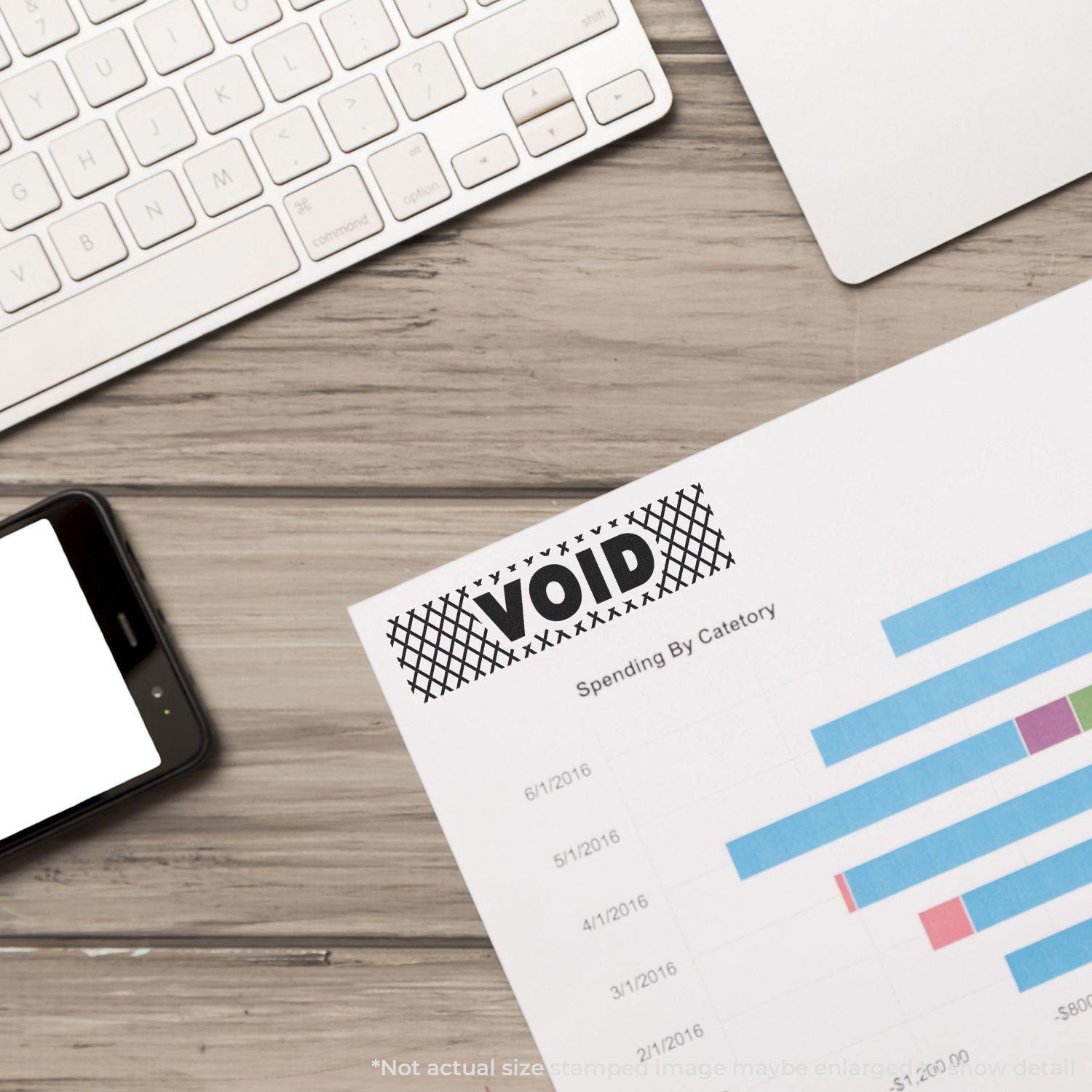 Large Pre-Inked Void with Strikelines Stamp marking a document on a desk with a keyboard and smartphone nearby.