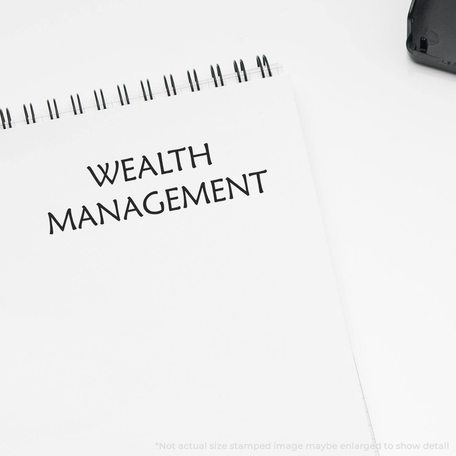 Large Pre-Inked Wealth Management Stamp used on a white notepad, displaying the text 'WEALTH MANAGEMENT' in bold black letters.