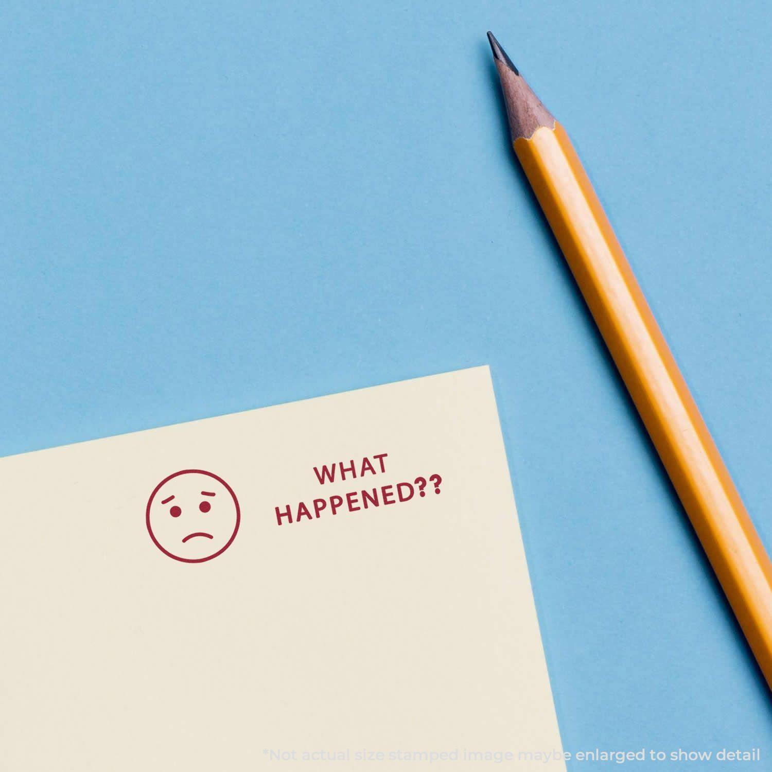 Yellow pencil next to a paper stamped with a large What Happened? rubber stamp and a sad face on a blue background.