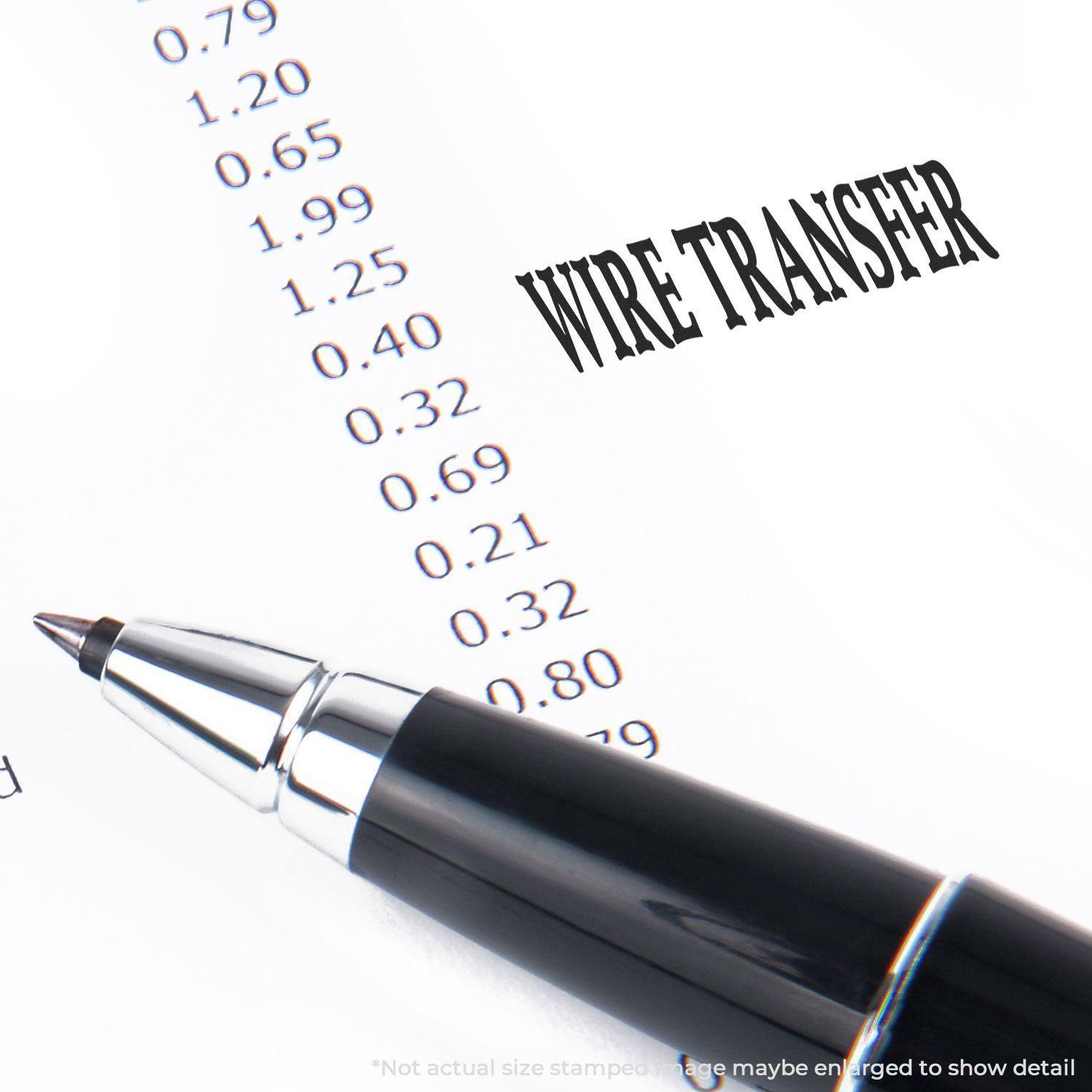 A pen rests on a document with the text WIRE TRANSFER stamped using the Large Pre-Inked Wire Transfer Stamp.