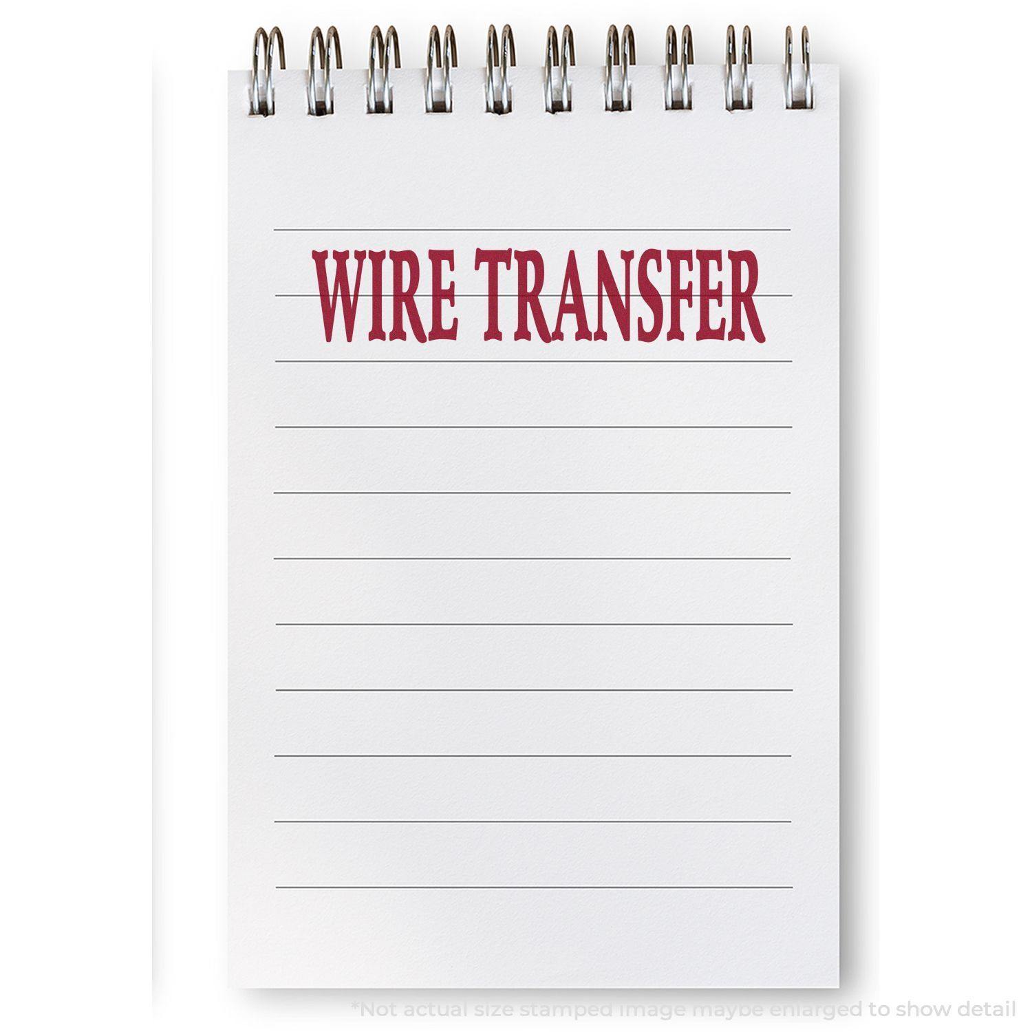 A Large Pre-Inked Wire Transfer Stamp imprint in red ink on a white notepad with lined pages and a spiral binding.