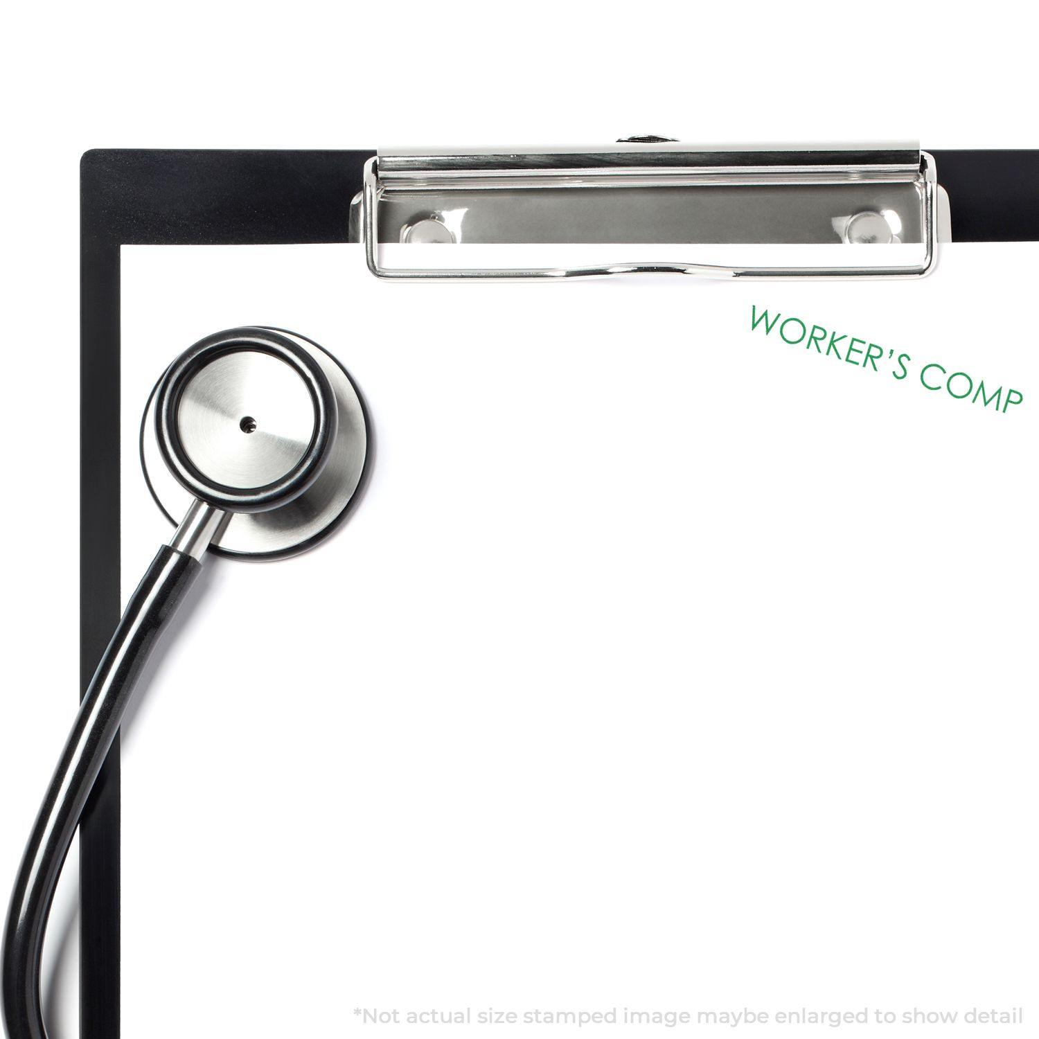 A stethoscope and clipboard with WORKER'S COMP stamped in green using the Large Pre-Inked Workers Comp Stamp.