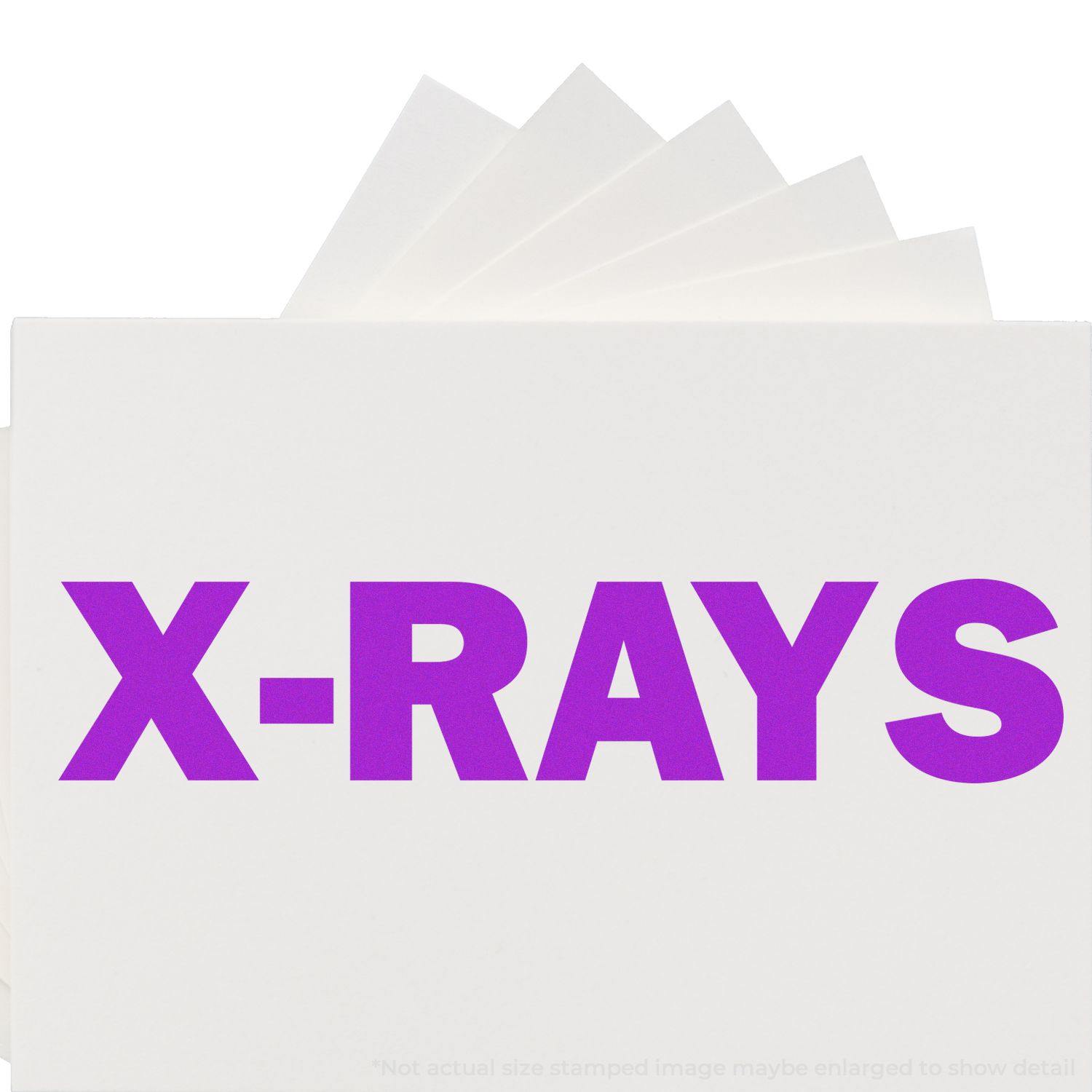 Large Pre-Inked X-Rays Stamp in use, displaying bold purple X-RAYS text on white paper.