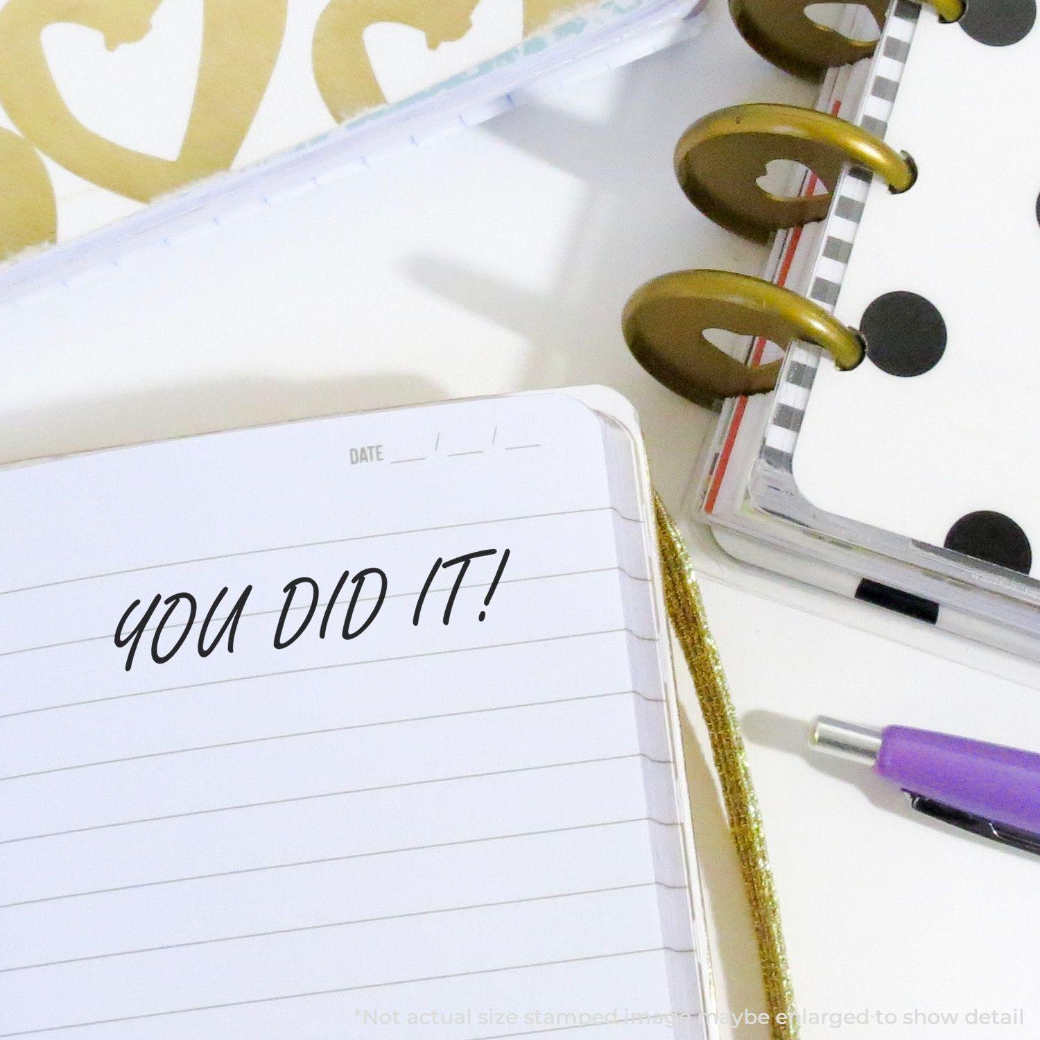 You Did It Rubber Stamp on a notebook page with planners, a pen, and gold accessories in the background.