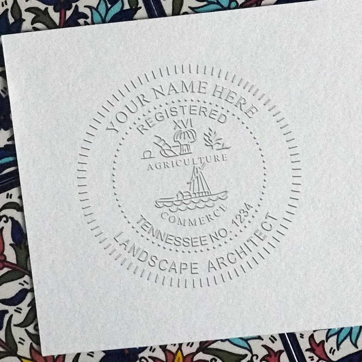 An in use photo of the Hybrid Tennessee Landscape Architect Seal showing a sample imprint on a cardstock