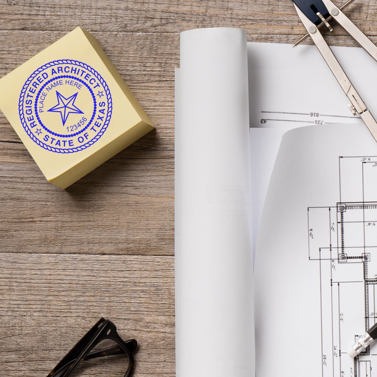 Texas Architect Seal Stamp next to architectural blueprints, compass, and glasses on a wooden desk.