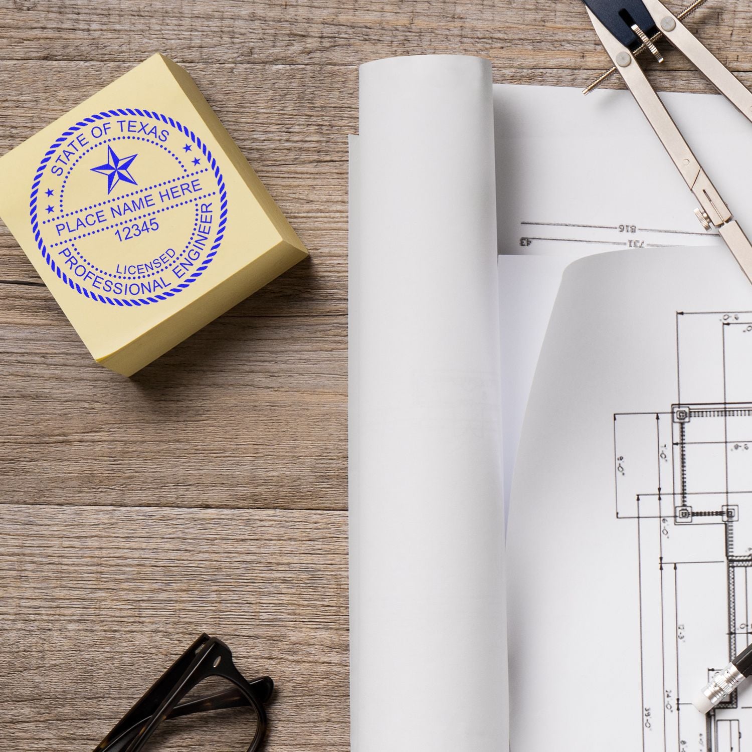 Self Inking Engineer Stamp of Seal on a yellow pad next to architectural blueprints, glasses, and drafting tools on a wooden desk.