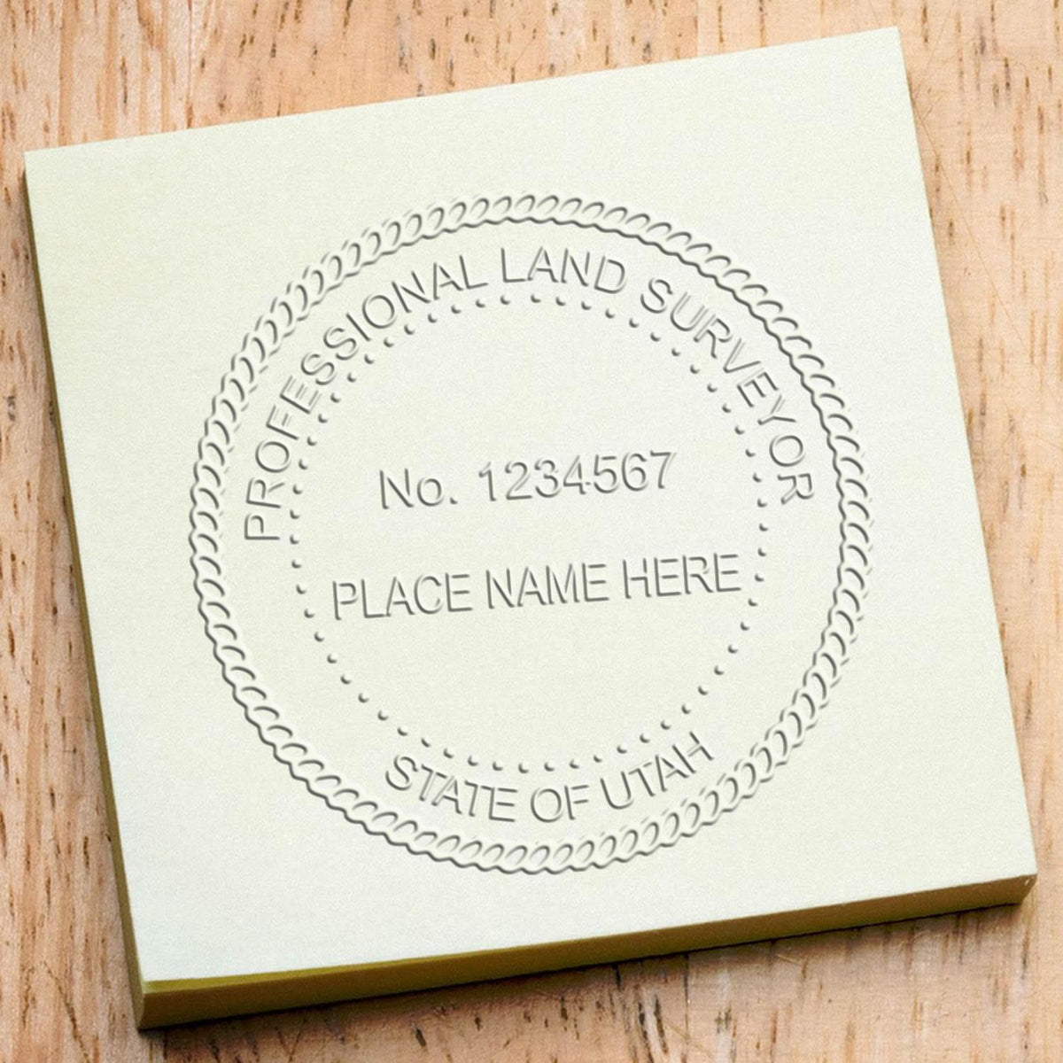 An in use photo of the Hybrid Utah Land Surveyor Seal showing a sample imprint on a cardstock