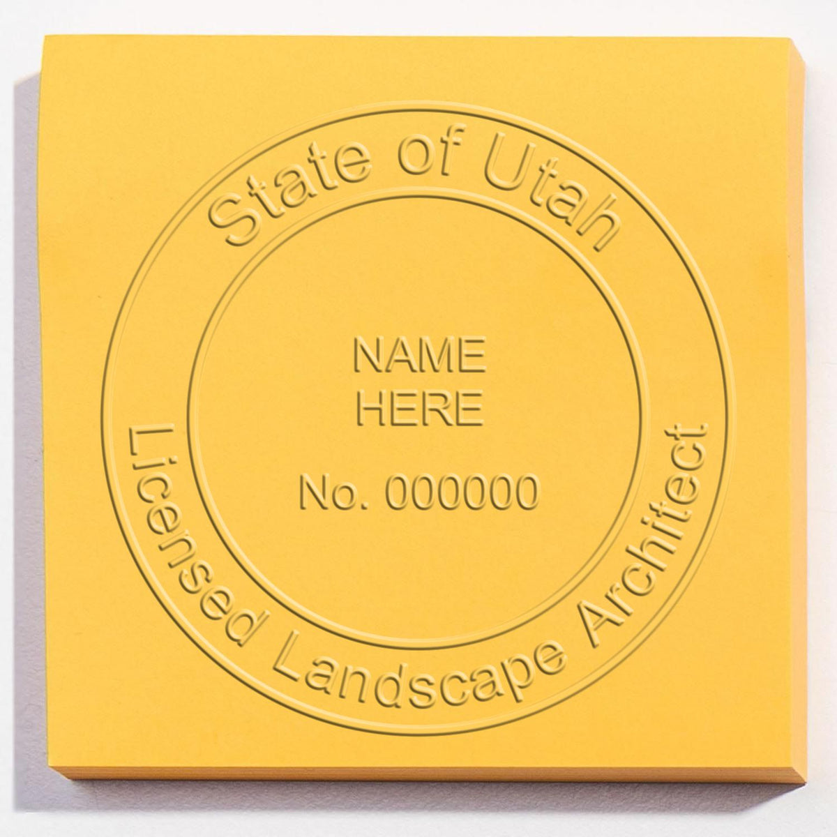 An in use photo of the Hybrid Utah Landscape Architect Seal showing a sample imprint on a cardstock