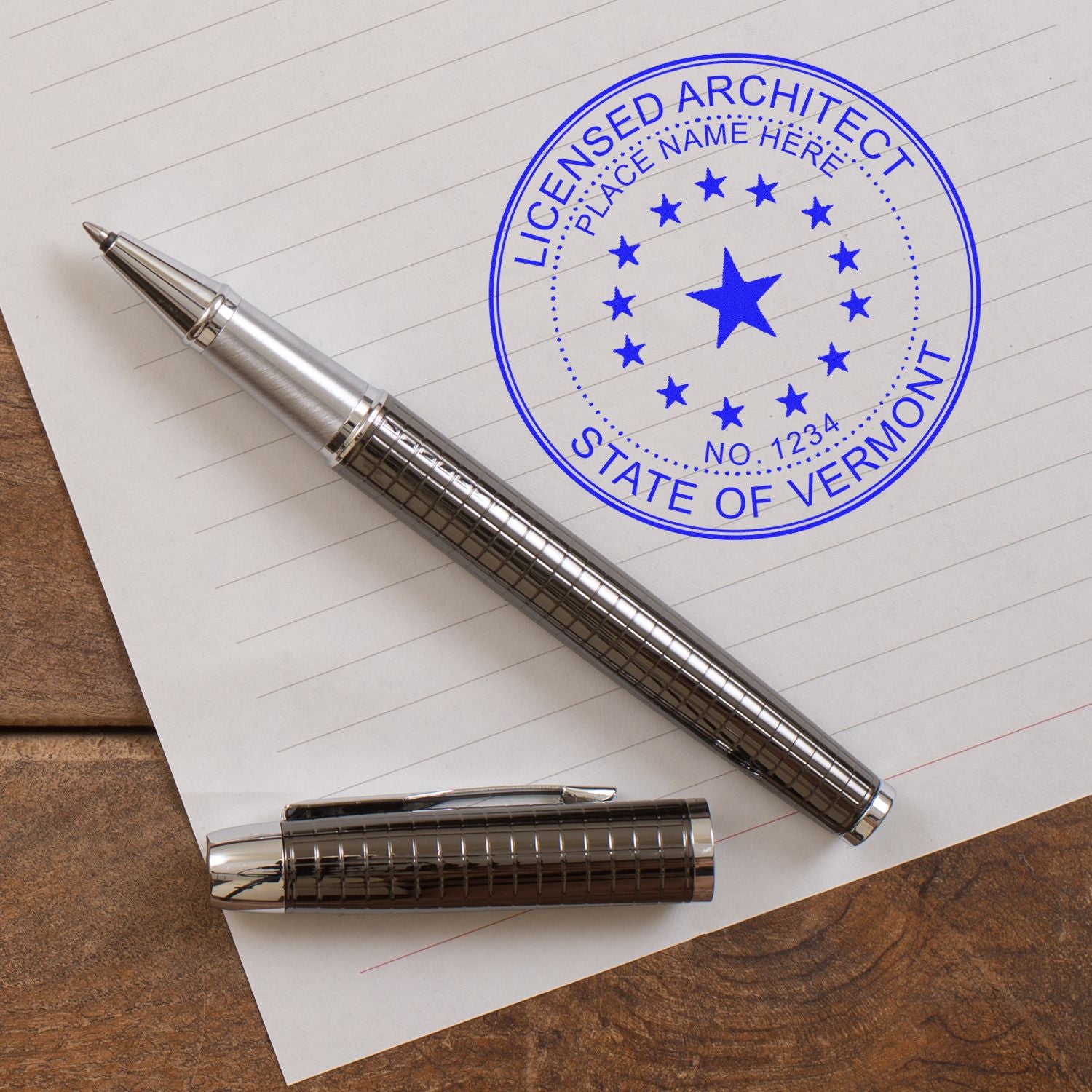 Self Inking Vermont Architect Stamp on paper with a pen beside it, displaying a blue licensed architect seal for the state of Vermont.