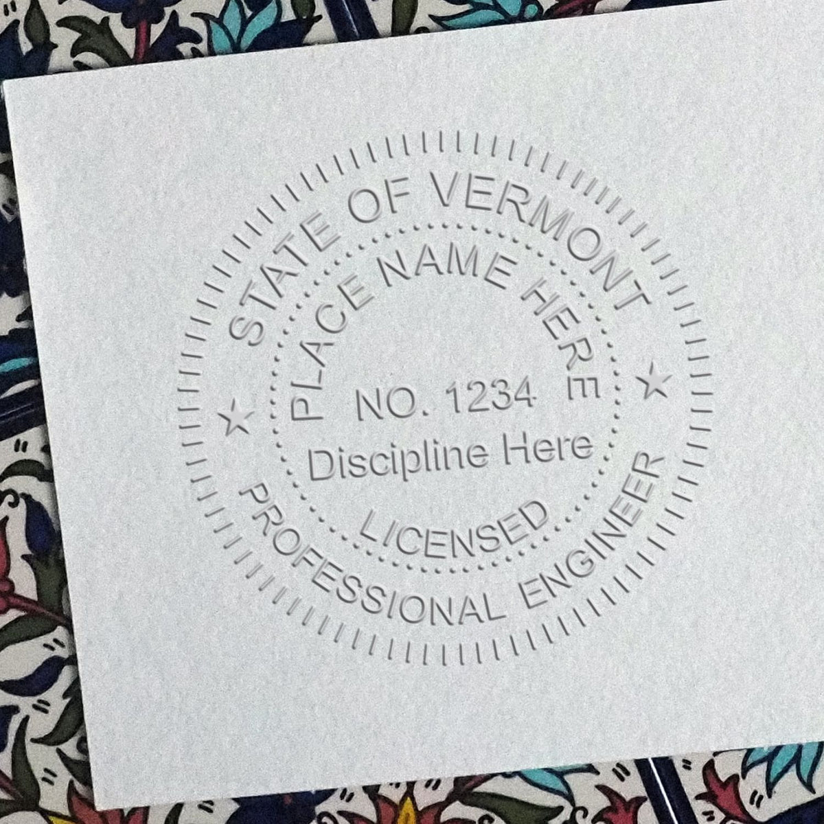 An in use photo of the Hybrid Vermont Engineer Seal showing a sample imprint on a cardstock