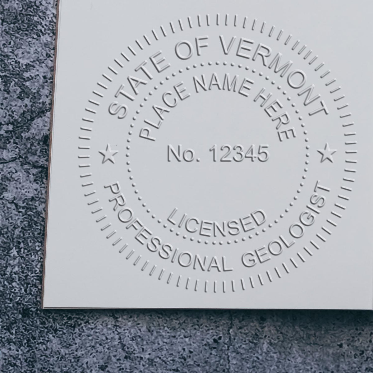 An in use photo of the State of Vermont Extended Long Reach Geologist Seal showing a sample imprint on a cardstock