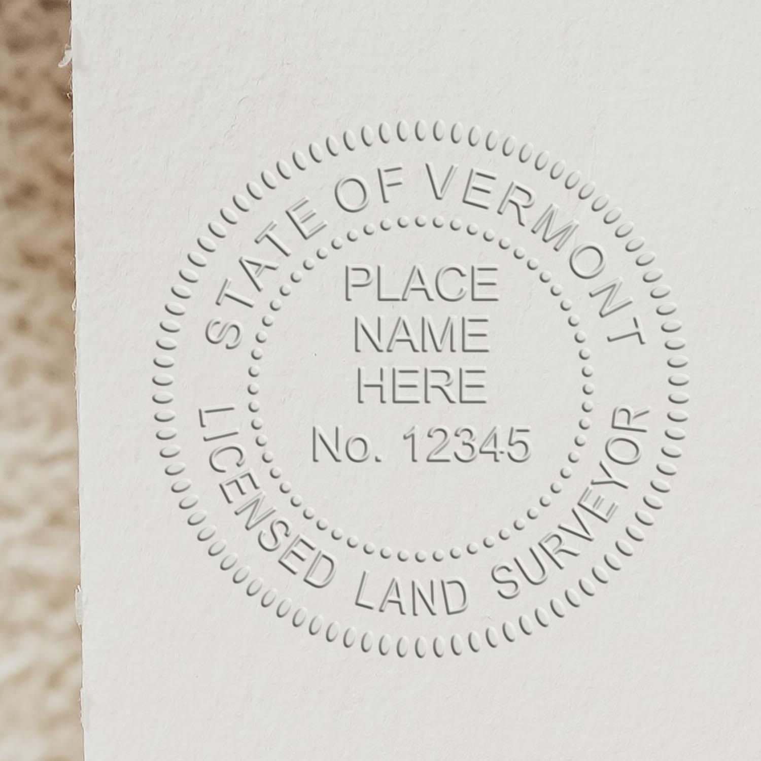 An alternative view of the Heavy Duty Cast Iron Vermont Land Surveyor Seal Embosser stamped on a sheet of paper showing the image in use