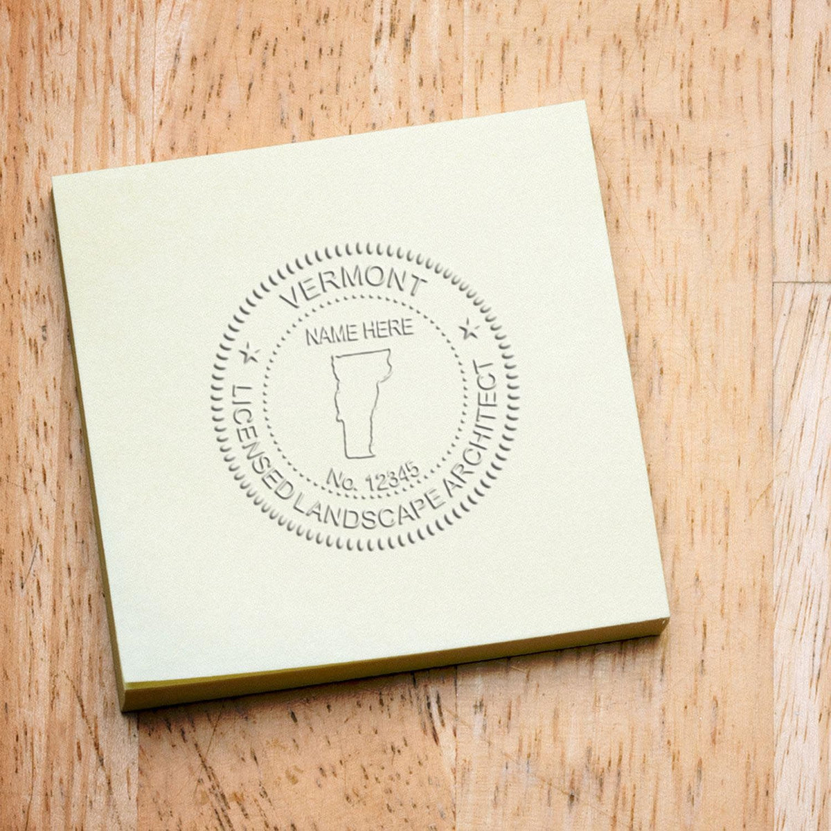 An in use photo of the Gift Vermont Landscape Architect Seal showing a sample imprint on a cardstock