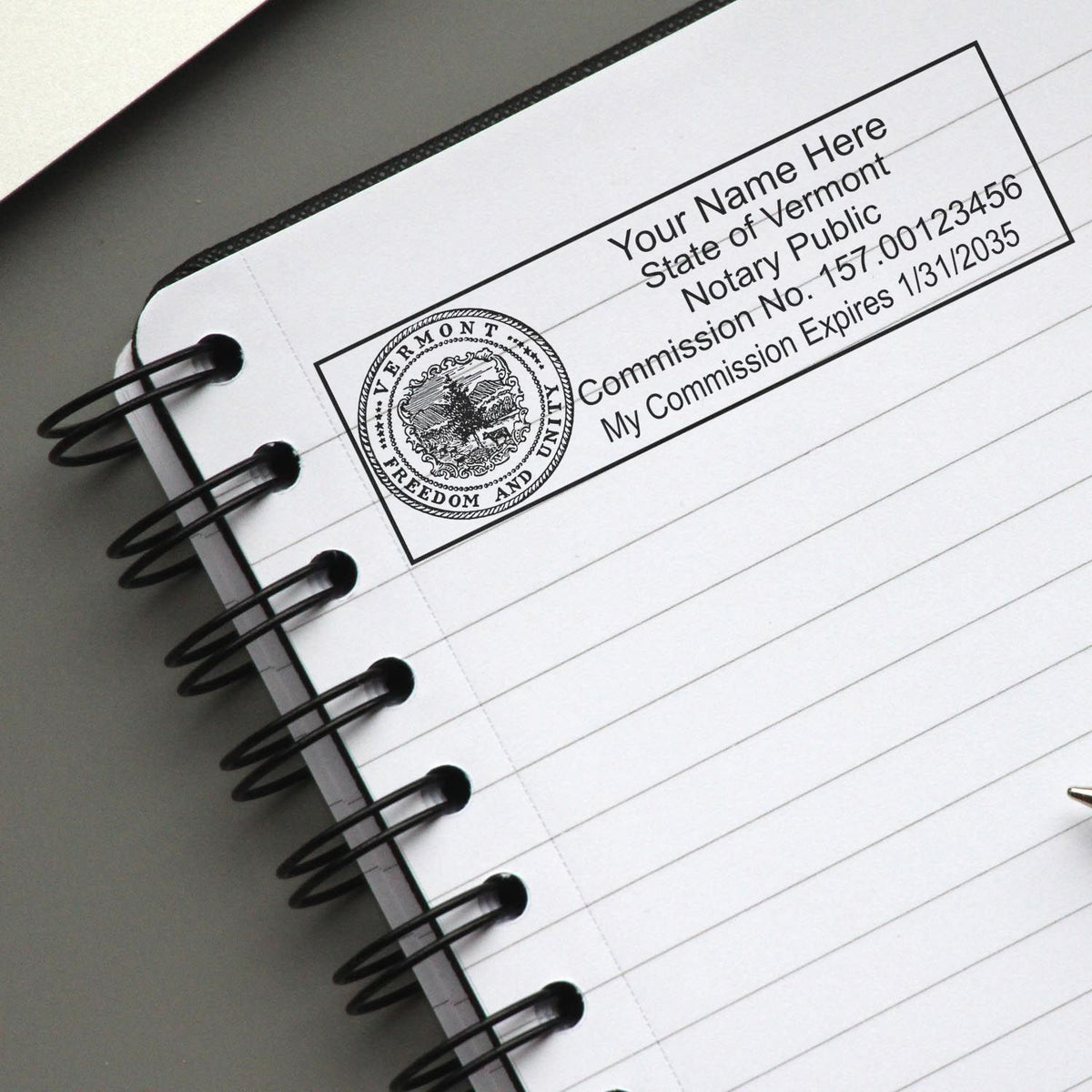 A lifestyle photo showing a stamped image of the MaxLight Premium Pre-Inked Vermont State Seal Notarial Stamp on a piece of paper