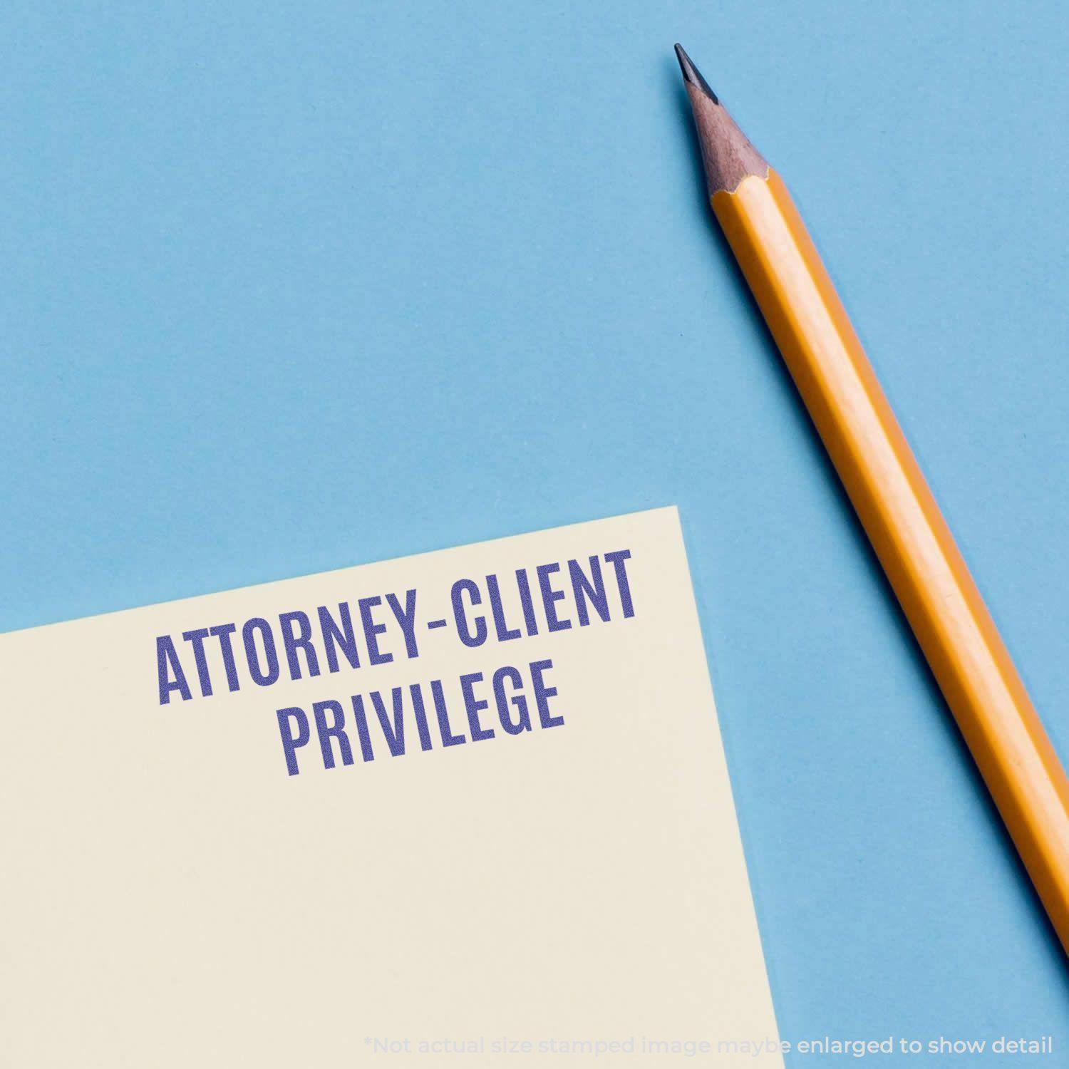 Attorney-Client Privilege Xstamper Stamp imprint on paper next to a sharpened yellow pencil on a blue background.