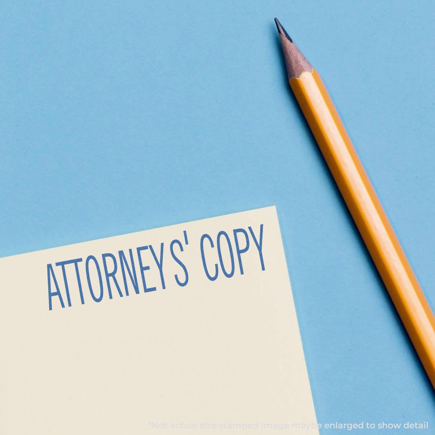 Attorney's Copy Xstamper Stamp imprint on paper next to a yellow pencil on a blue background.