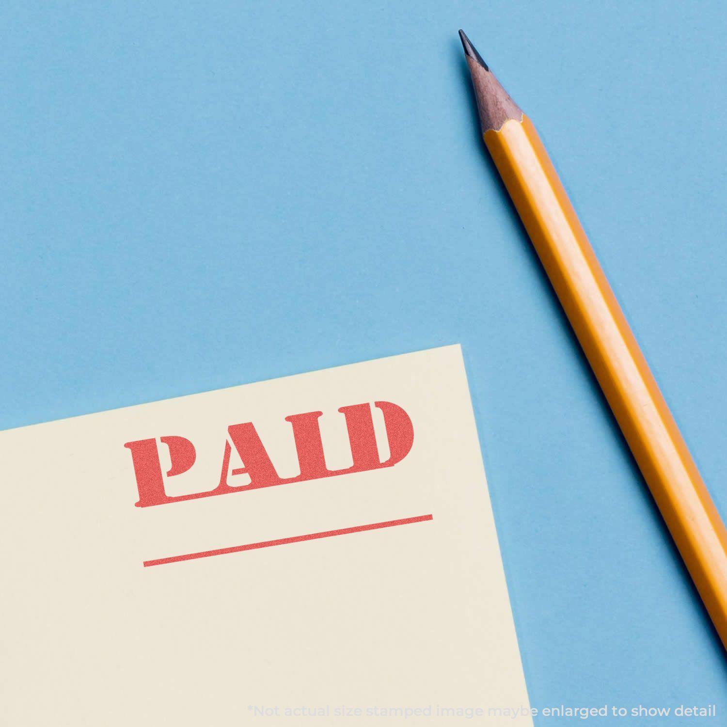 A yellow pencil next to a paper stamped with PAID in red ink using the Bold Red Paid Xstamper Stamp on a blue background.