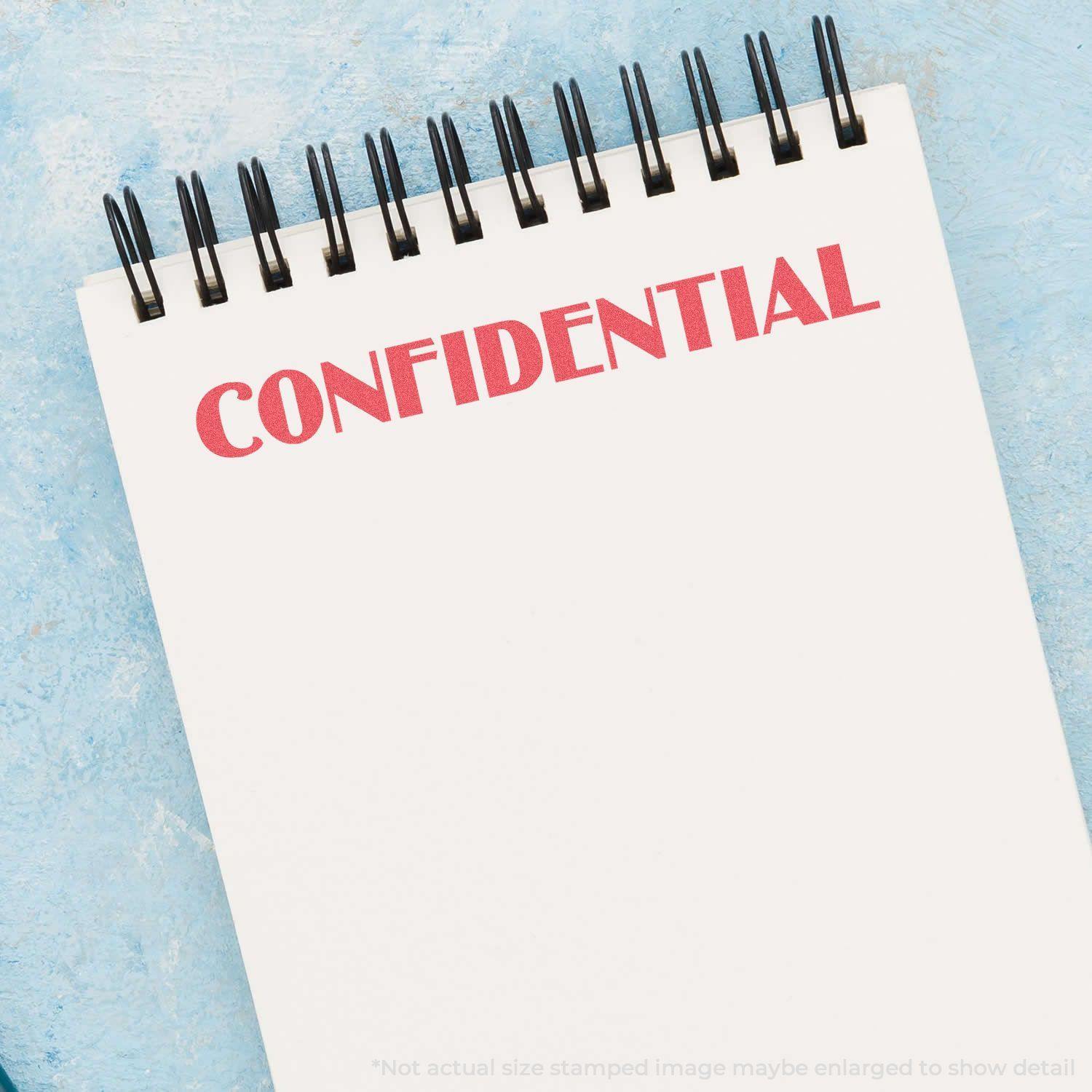 Notebook with 'CONFIDENTIAL' stamped in red using the Confidential Xstamper Stamp, placed on a blue textured surface.