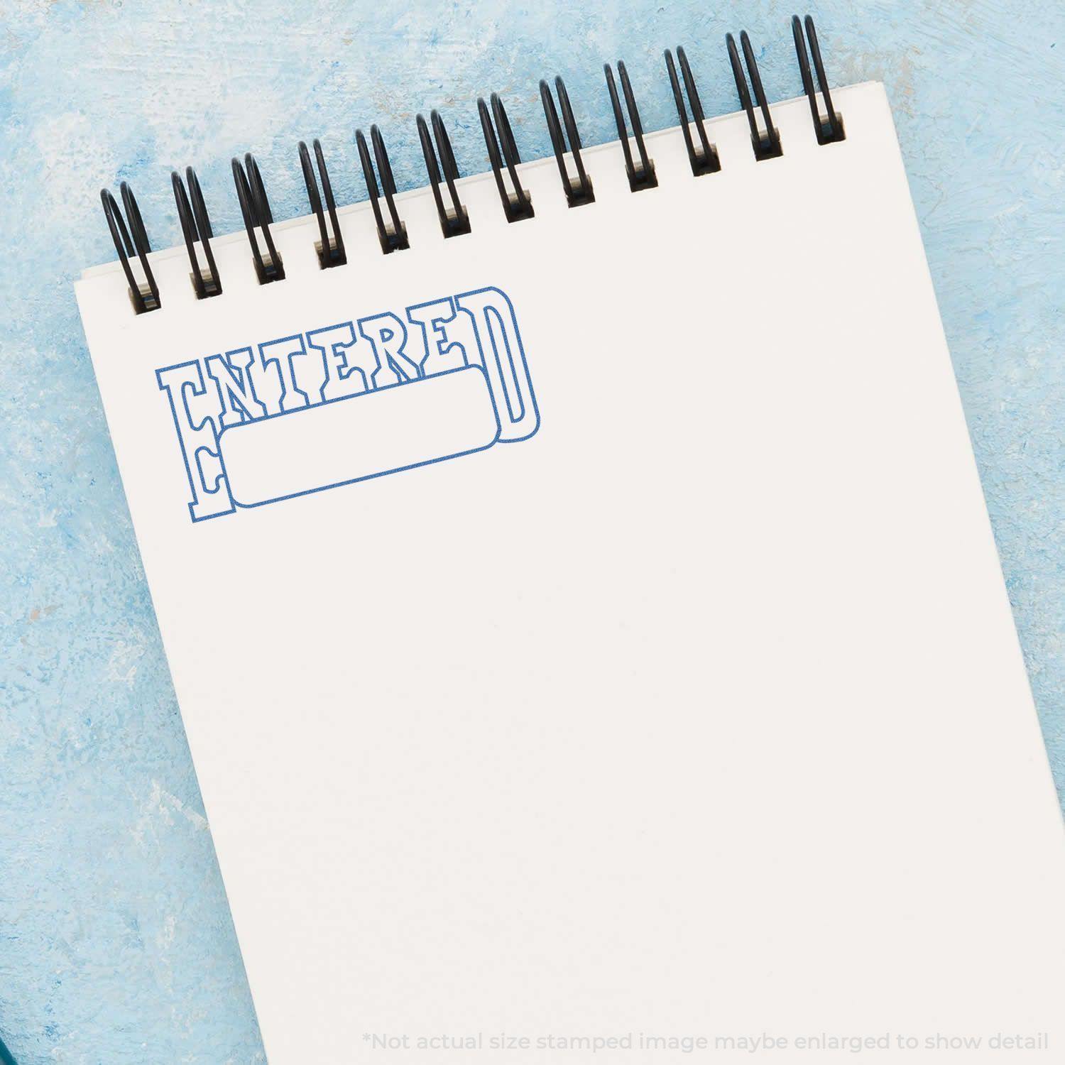 A notebook with a blue ENTERED stamp impression at the top left corner, created using the Date Entered Xstamper Stamp.