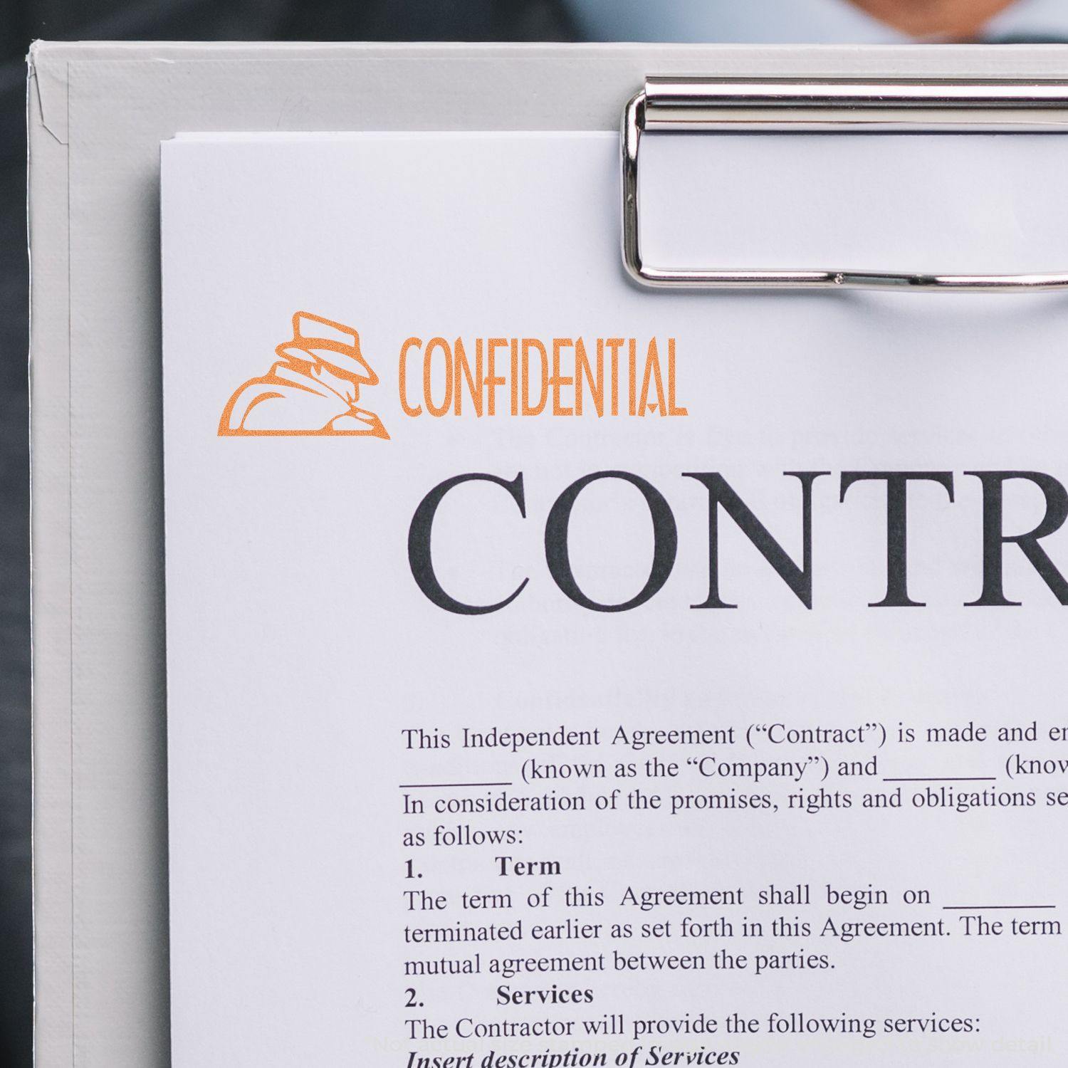 Figure Confidential Xstamper Stamp marking CONFIDENTIAL in orange on a document clipped to a clipboard.