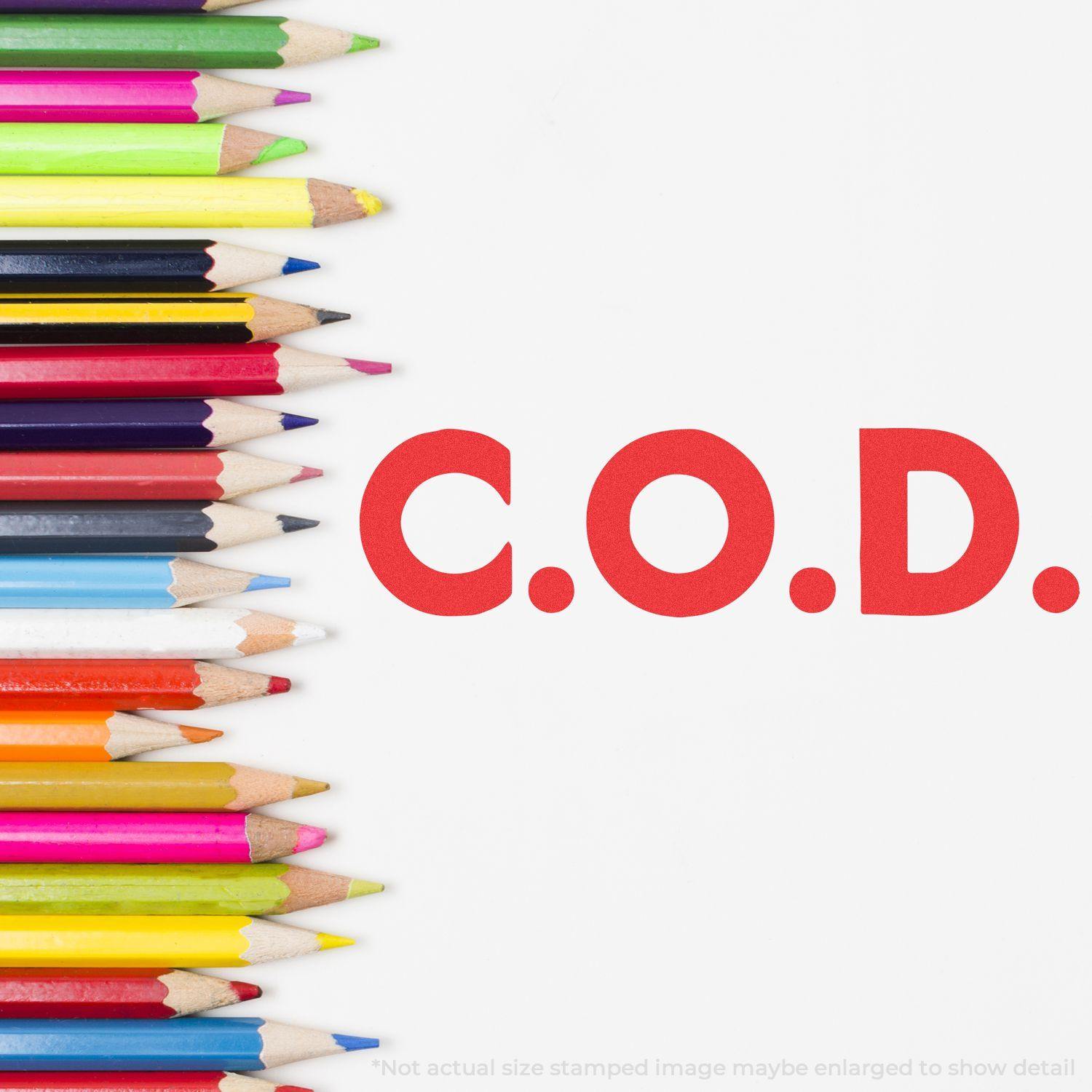 Colorful pencils next to the bold red C.O.D. mark made by the Jumbo Bold Red C.O.D. Xstamper Stamp.