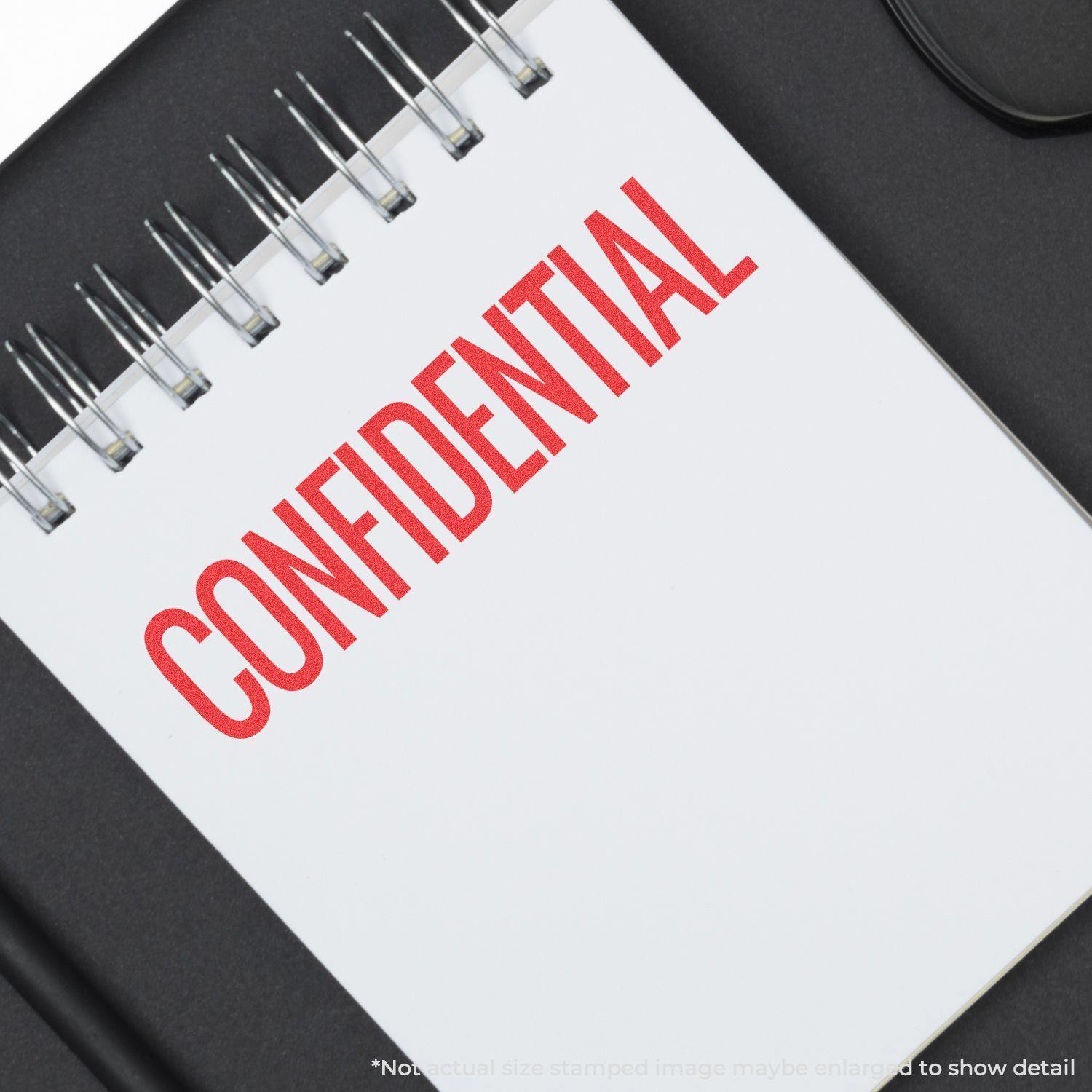 Jumbo Bold Red Confidential Xstamper Stamp imprint on a white notepad, showing the word CONFIDENTIAL in large red letters.