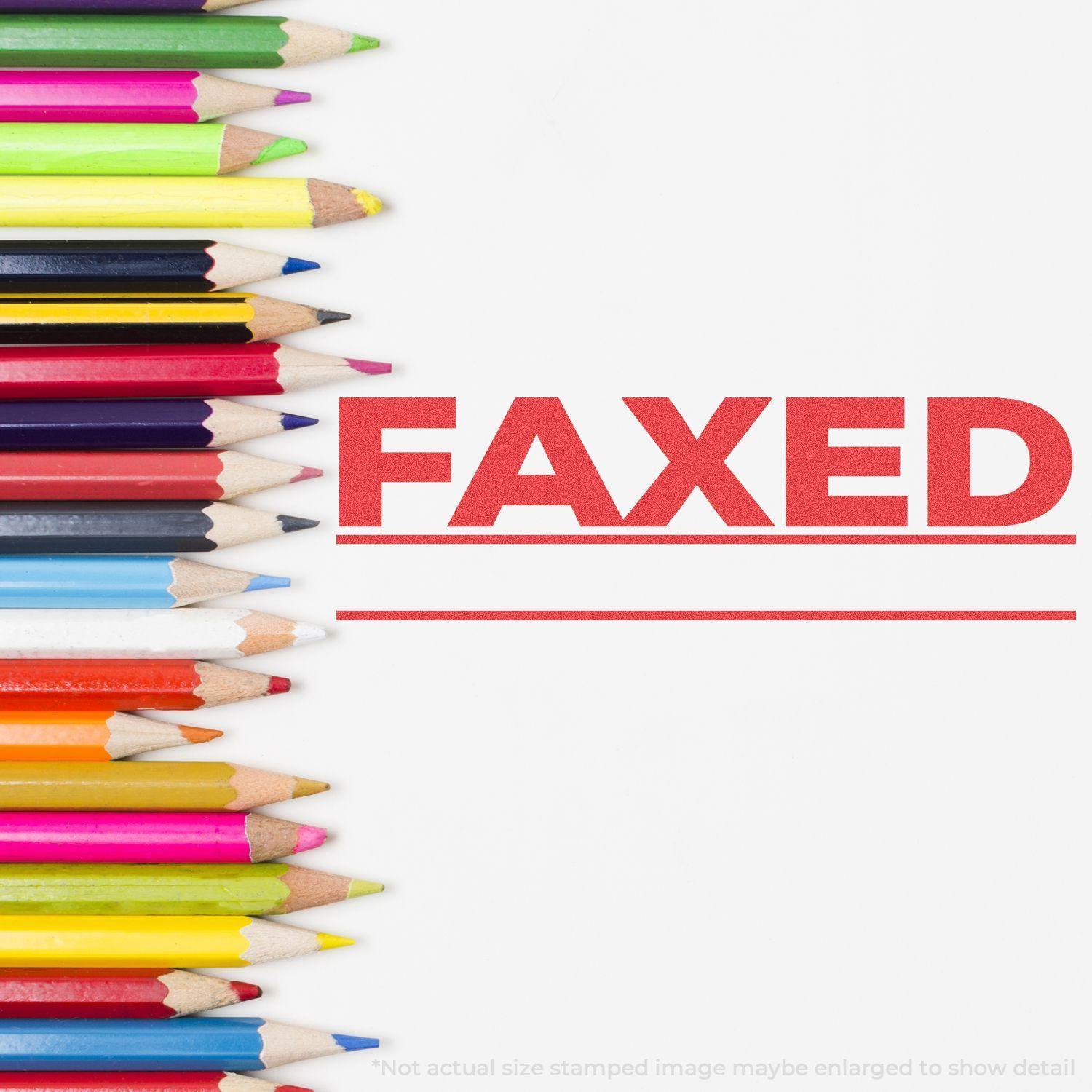 Jumbo Bold Red Faxed Xstamper Stamp impression next to a row of colorful pencils on a white background.