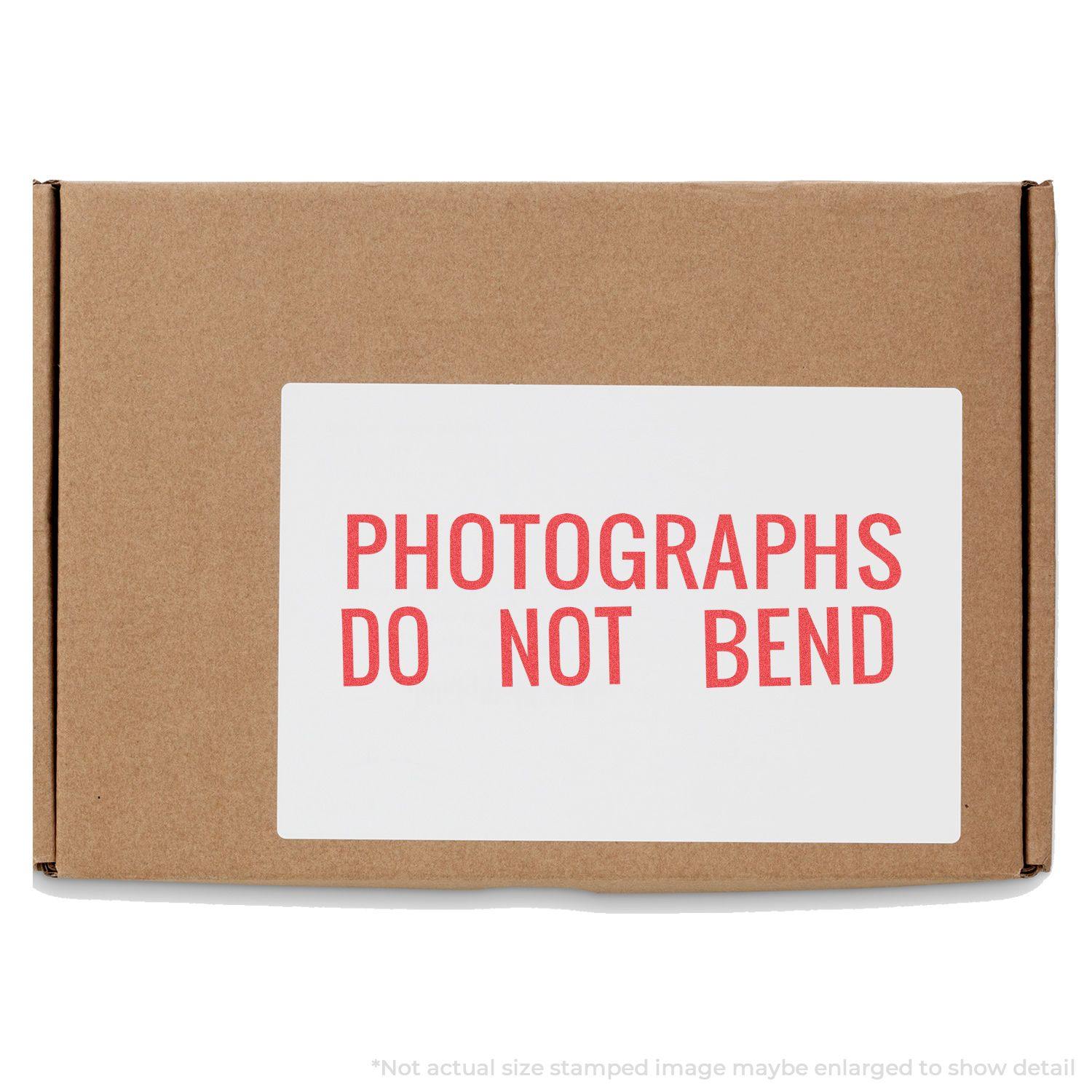 Cardboard box with a white label stamped in red ink reading PHOTOGRAPHS DO NOT BEND using the Jumbo Photographs Do Not Bend Xstamper Stamp.