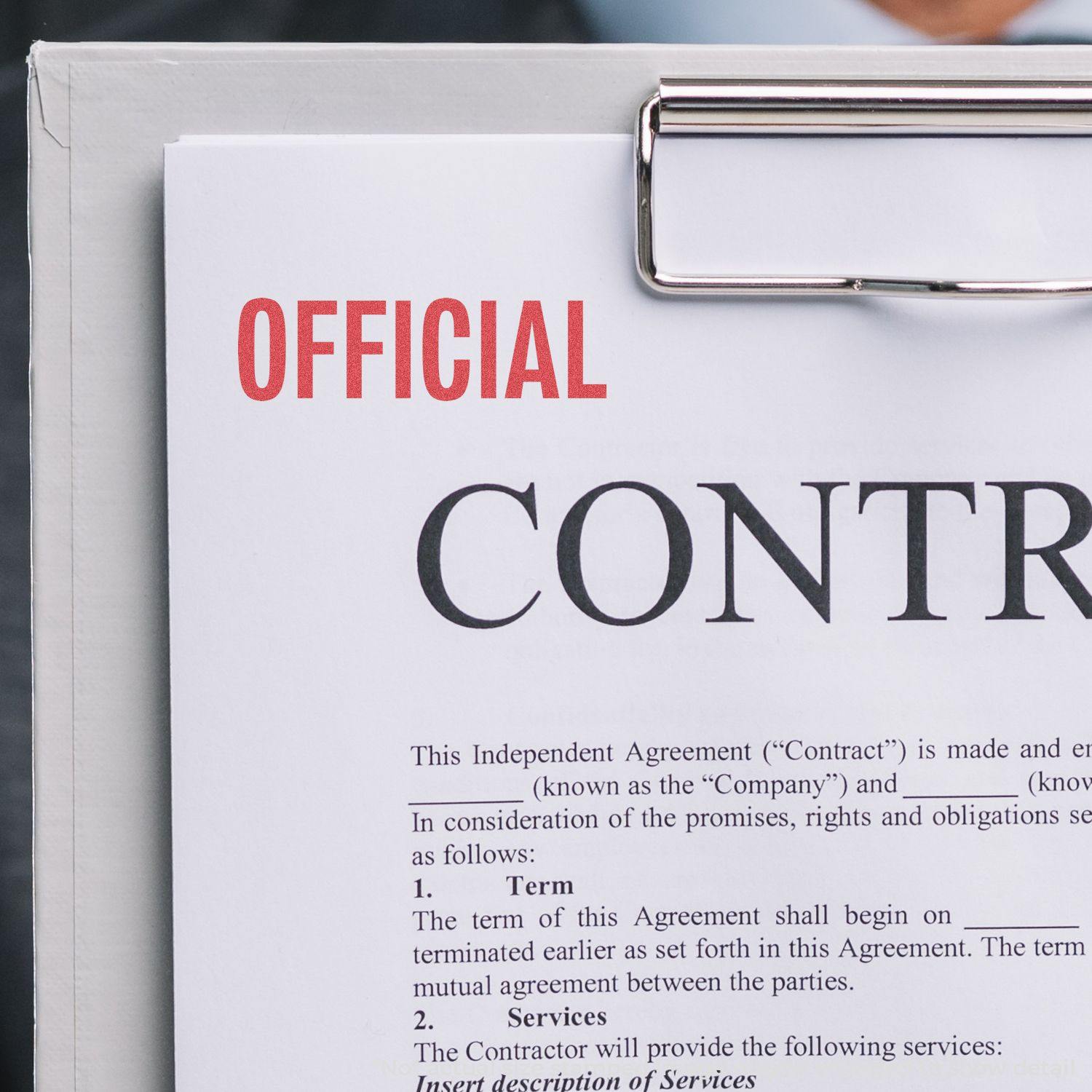 Official Xstamper Stamp marking "OFFICIAL" in red on a contract document held by a clipboard.