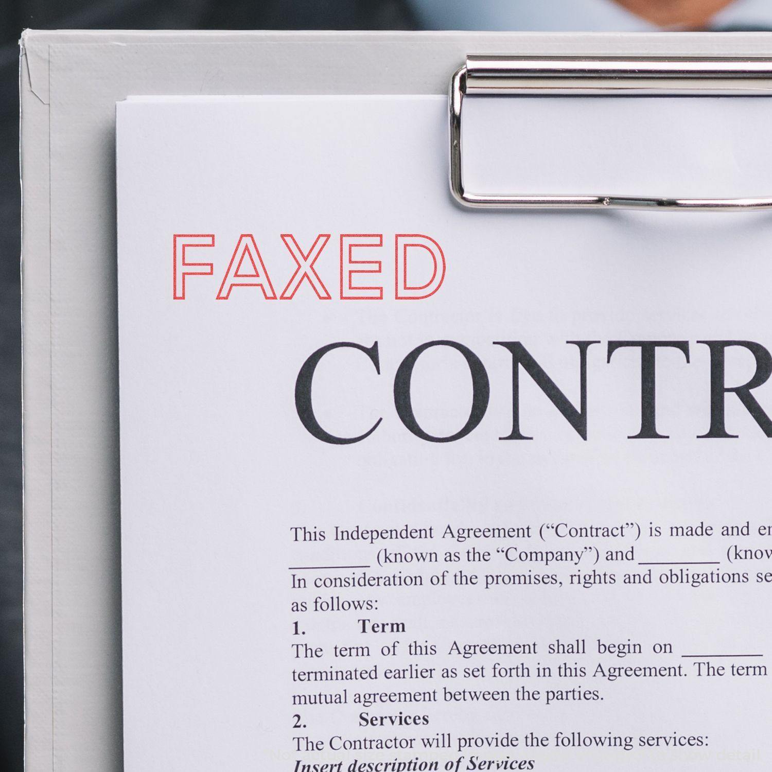 A clipboard holding a contract stamped with FAXED in red using the Red Faxed Xstamper Stamp.