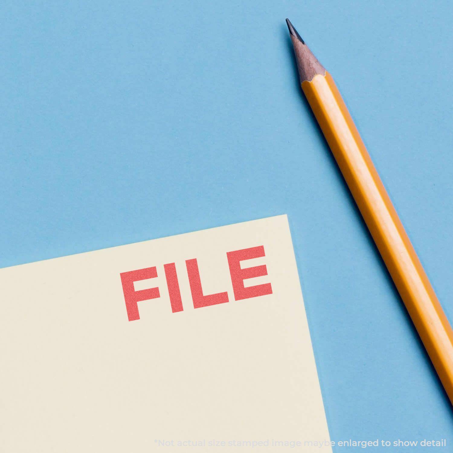 A yellow pencil next to a document stamped with FILE in red using the Red File Xstamper Stamp on a blue background.