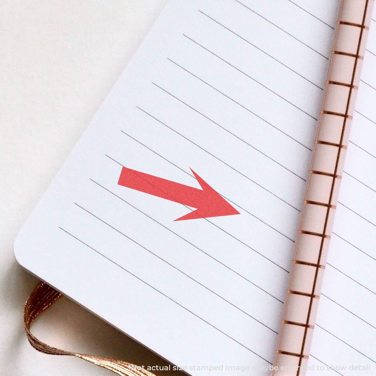 Round Arrow Xstamper Stamp imprint in red on a lined notebook page, showing a clear and precise arrow pointing to the right.