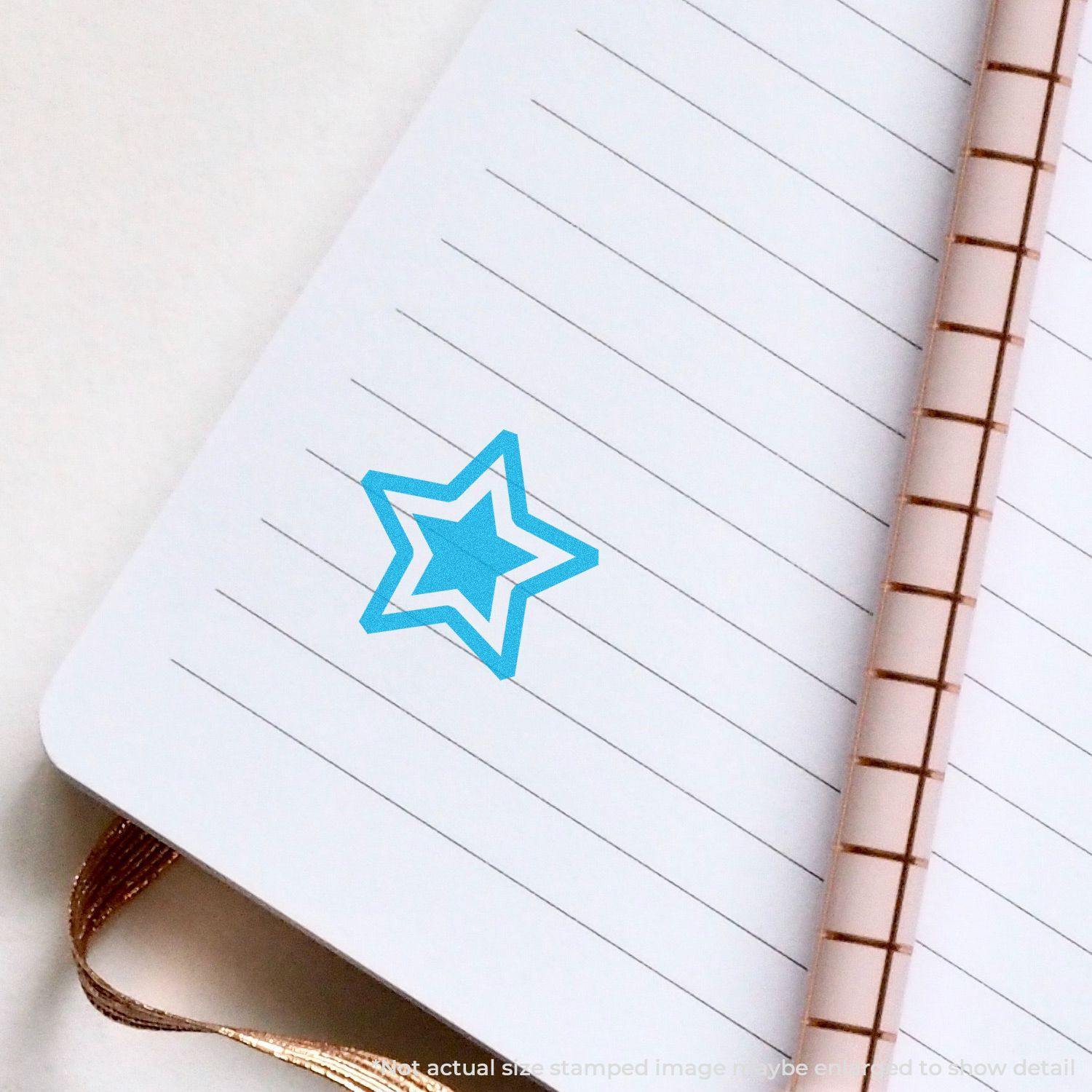 Round Blue Star Xstamper Stamp imprint on a lined notebook page, showing a blue star design.