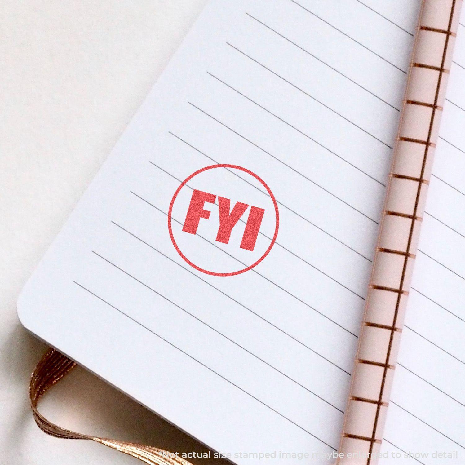 Round FYI Xstamper Stamp in red ink on an open notebook with lined pages and a spiral binding.