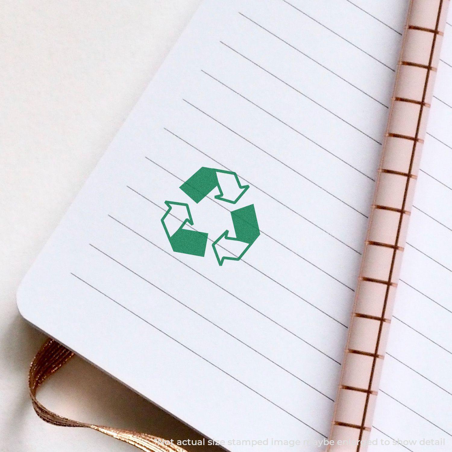 Round Recycle Logo Xstamper Stamp imprint on a lined notebook page, showing a green recycling symbol.