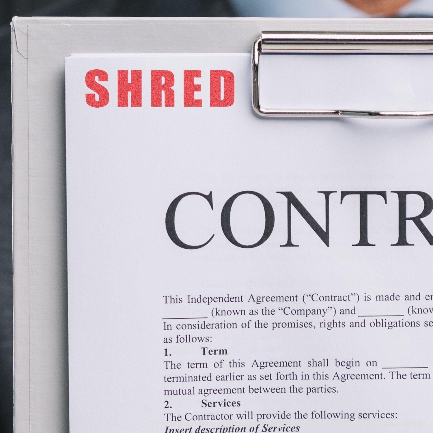 A clipboard with a document stamped SHRED using the Shred Xstamper Stamp, indicating the document is to be destroyed.